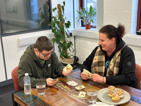 ABOVE:  Josh with Agnieszka at Care Horizons HQ enjoying a game of cards and cake!